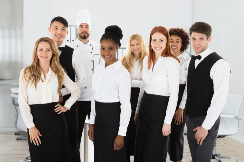 A group of staff in uniform smiles into the camera